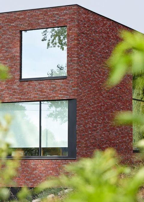 Rode gevelsteen en grijs buitenschrijnwerk