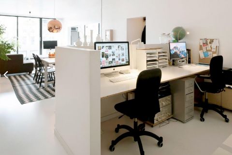 Bureau achter laag muurtje in woonkamer