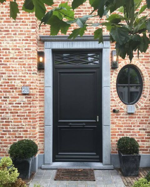 Klassieke zwarte voordeur met bovenlicht en arduinen omkadering