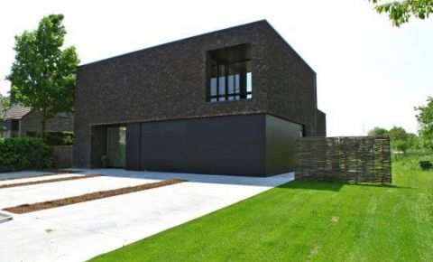 Zwarte gevelbeplating en donker metselwerk